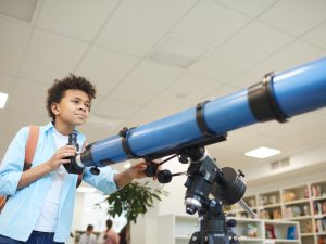 Niño afroamericano con telescopio